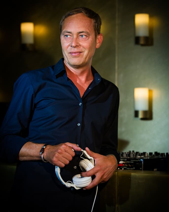 DJ Mike Lindström am Mischpult mit Köpfhörern in der Hand